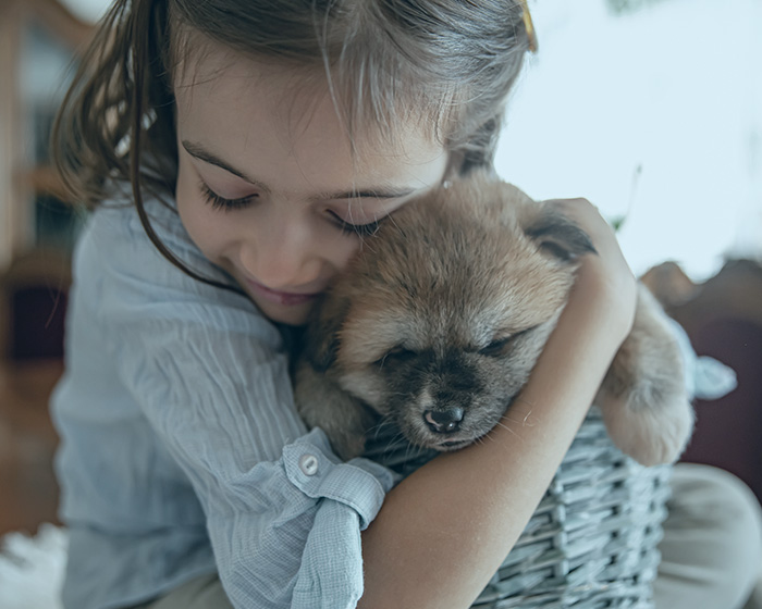 Niña abrazando a su cachorro
